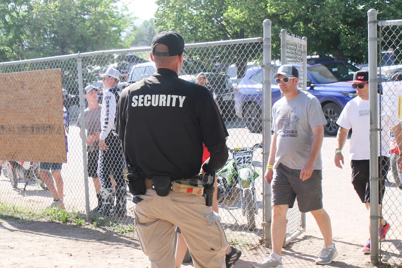 security guard watching people walking through a gate