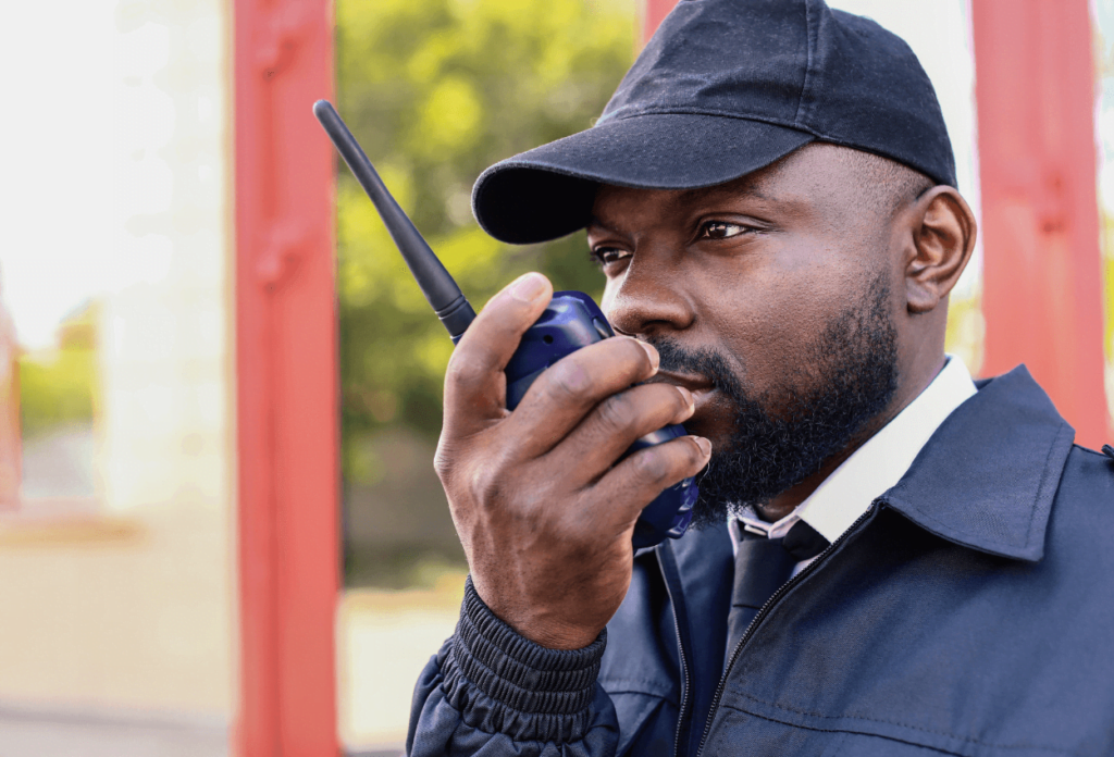 The image shows a close-up of a bar security guard talking into his walkie talkie.