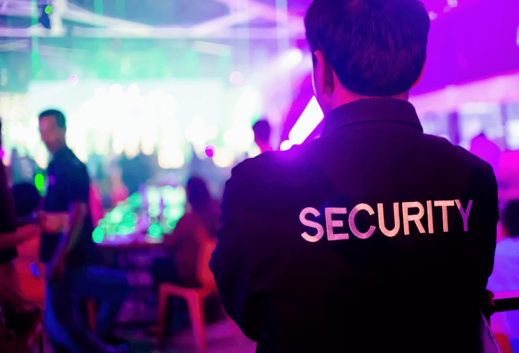 A security guard watching over a crowded bar