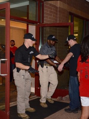 Security personnel performing checks outside a building entrance.