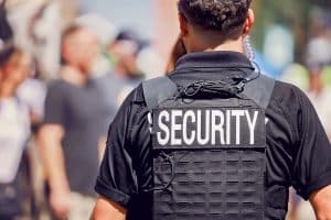 photo of back of man wearing vest reading security