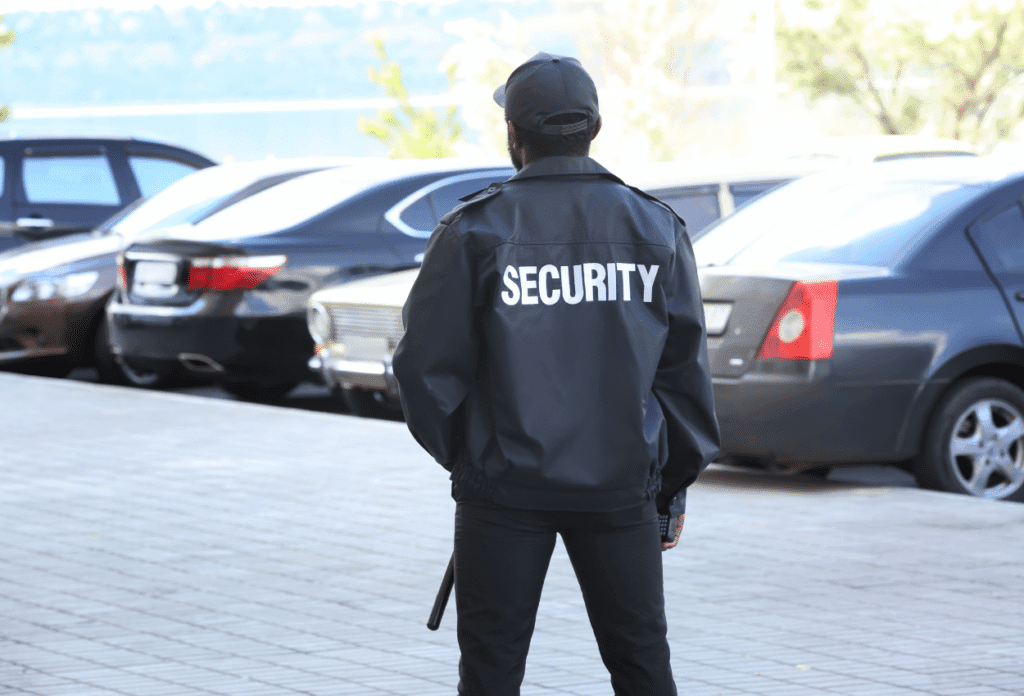 A picture of a security guard patrolling a parking lot full of cars.